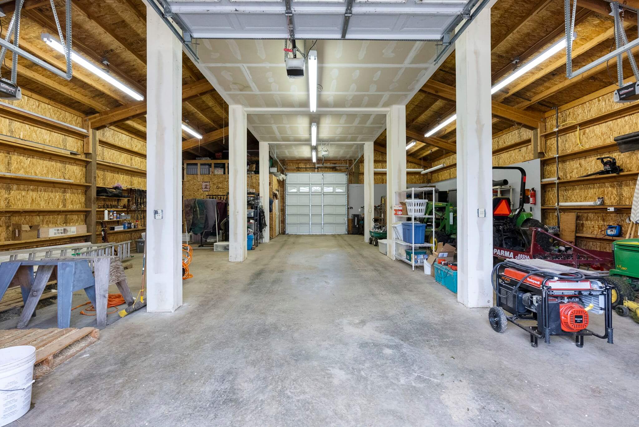 Newer barn with concrete floors is currently used as a shop but could make an excellent show horse barn with the addition of stalls
