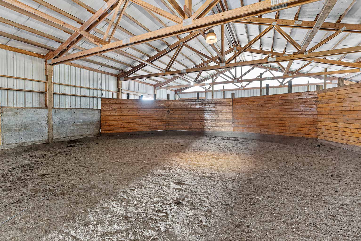 Smaller barn includes a 60' covered round pen with viewing platform